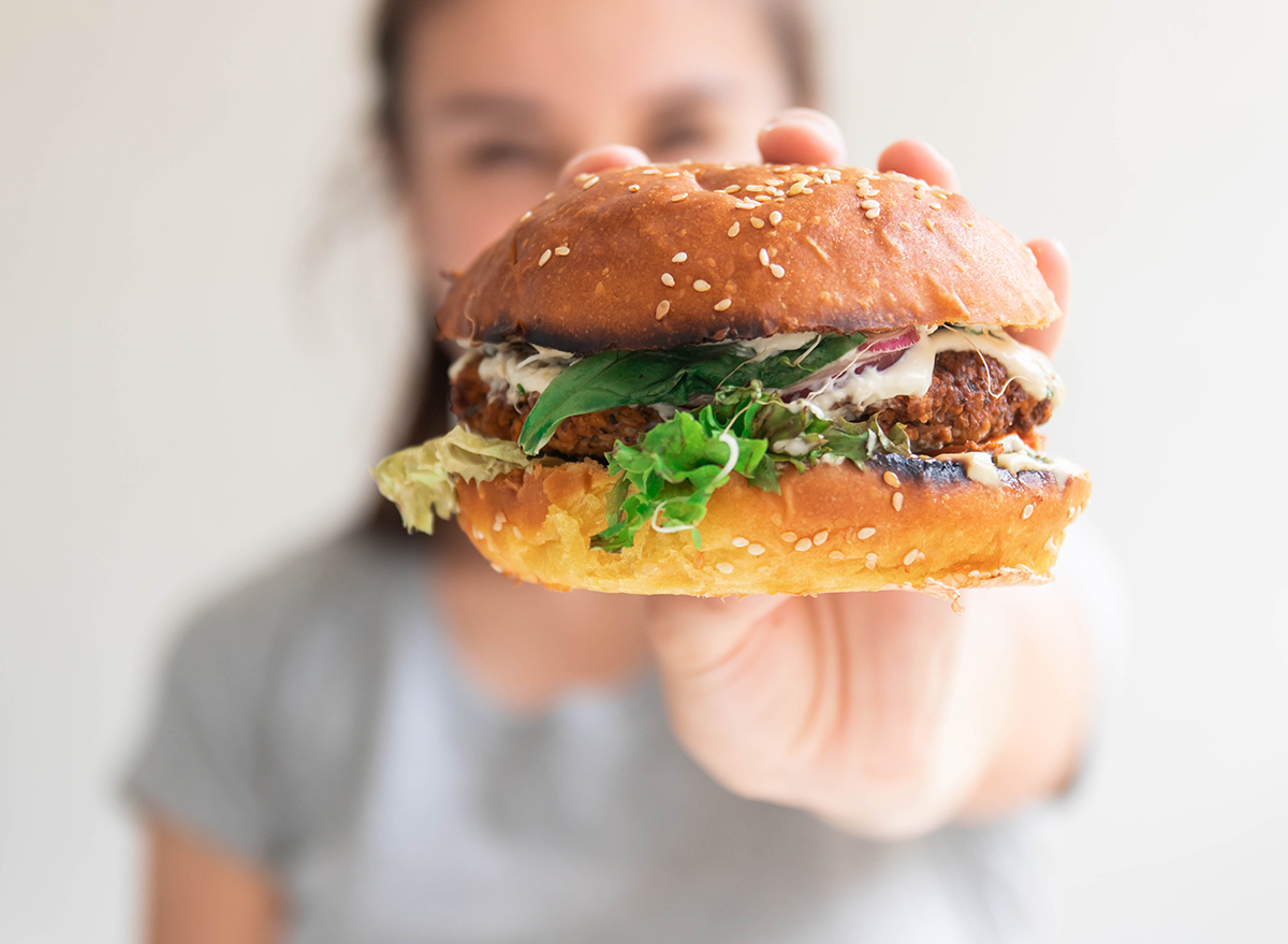 Vegan,Veggie,Burger,Closeup,In,Girl,Hands.,Happy,Woman,Tasting,And