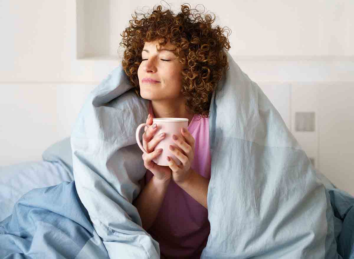 Relaxed,Curly,Woman,With,Closed,Eyes,Wrapped,In,Blanket,While