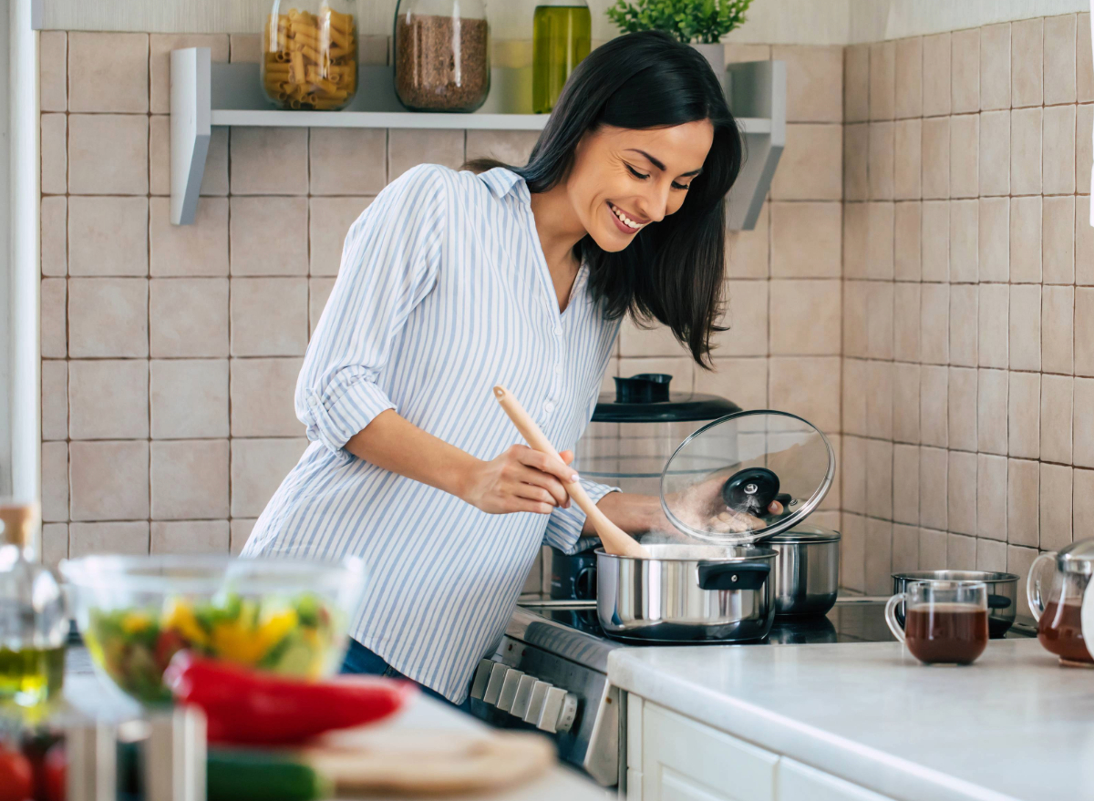 woman cooking healthy dinner for weight loss in bright kitchen
