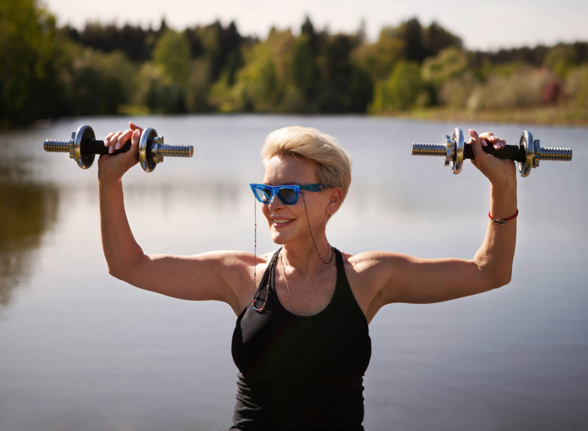 fit mature woman lifting dumbbells, concept of exercises to look younger