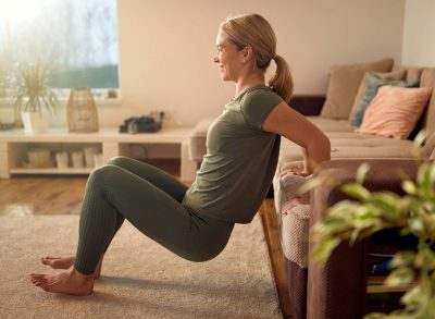 woman doing tricep dips, concept of at-home workouts to melt turkey wing arm fat