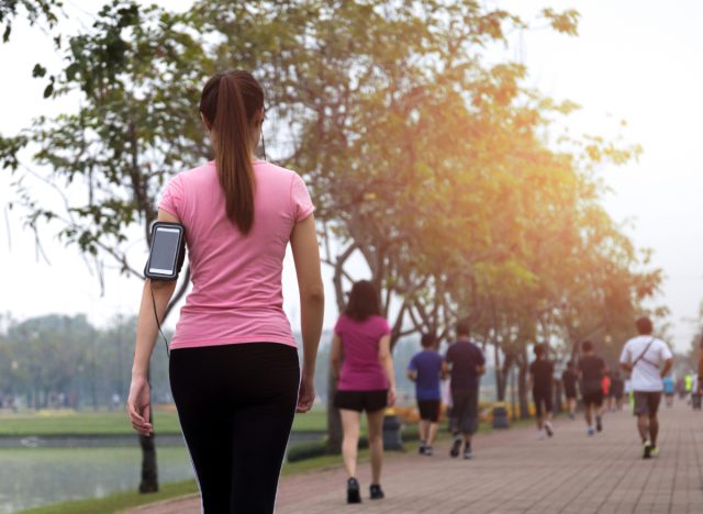 woman walking on sidewalk for exercise, concept of benefits for walking after meal