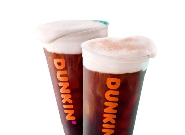 two Dunkin' cold brew cups with sweet cream cold foam on top