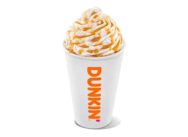 cup of Dunkin' latte with whipped cream and caramel swirl on white background