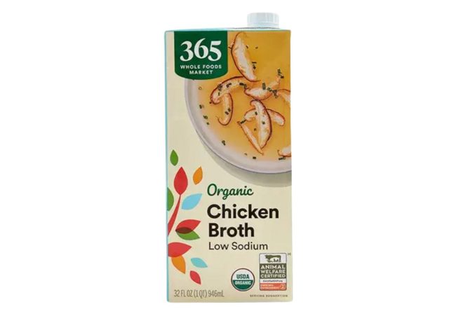 box of Whole Foods low sodium chicken broth on white background