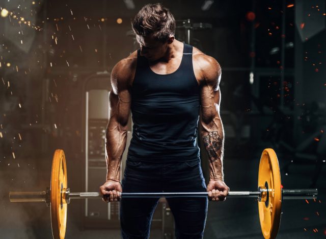 fit, muscular man doing barbell bicep curls, concept of daily workout for men to build bigger arms