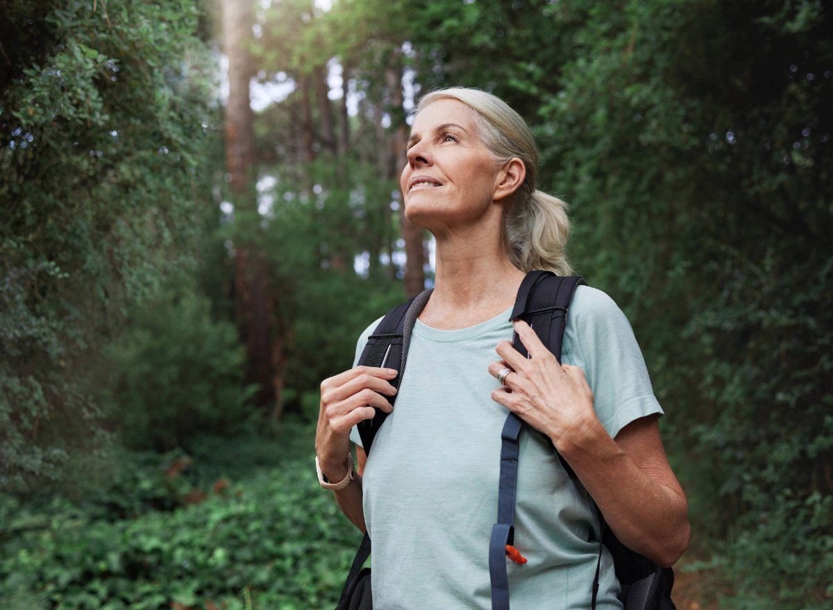 happy mature woman hiking, concept of the #1 daily habit for a longer life