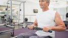 mature man doing rowing exercise, concept of strength exercises to stay fit