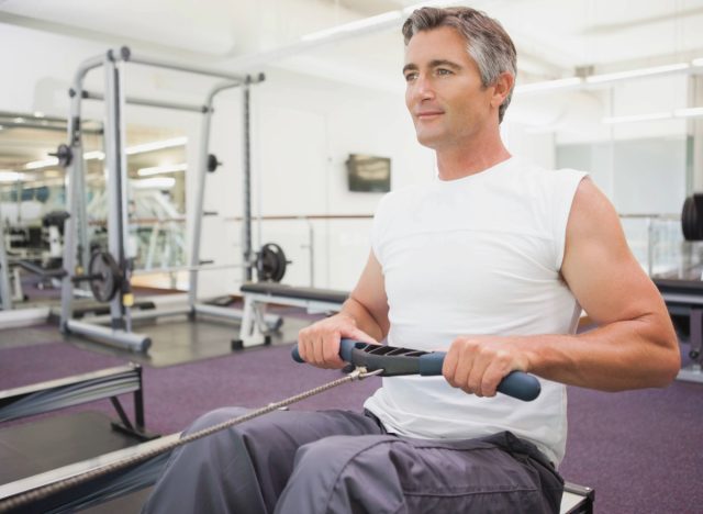 mature man doing rowing exercise, concept of strength exercises to stay fit