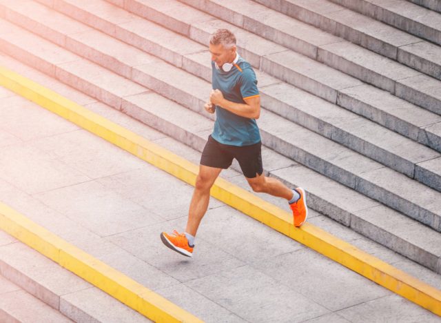 middle-aged man doing high-impact run on stairs outdoors, concept of exercise habits that destroy your body after 50