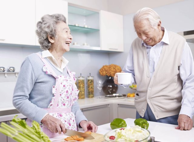 happy Japanese couple making healthy meal at home