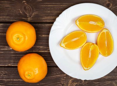 oranges and slices on plate, concept of orange peel hack