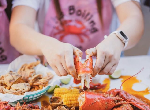 person cracking open lobster at the boiling crab