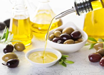pouring olive oil into small bowl, concept of drinking olive oil to lose weight