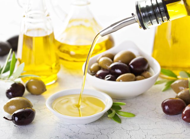 pouring olive oil into small bowl, concept of drinking olive oil to lose weight