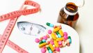 concept of weight-loss supplements with scale and tape measure