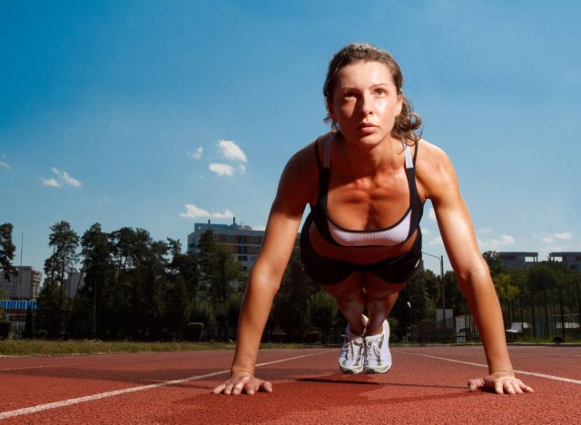 fit woman doing pushups or planks on track, concept of bodyweight workouts for flabby arms