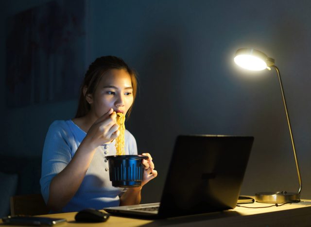 woman eating dinner while working