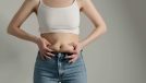 woman holding belly fat, concept of worst habits for belly fat