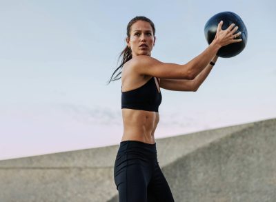 woman doing medicine ball exercise, concept of waist exercises for stronger obliques