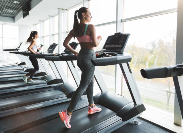 woman power walking on the treadmill, concept of treadmill or elliptical which is more effective