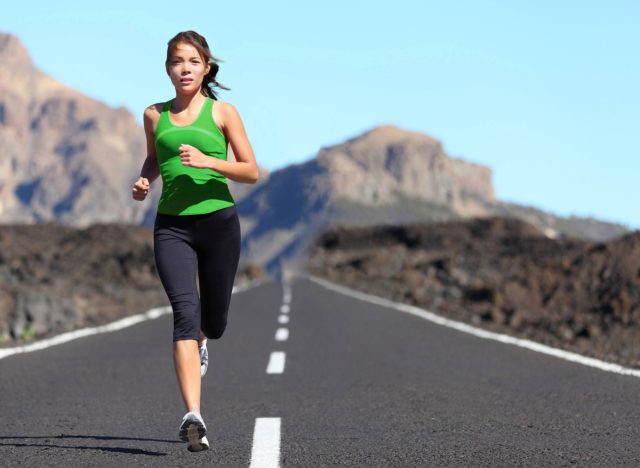 woman running outdoors, mountain backdrop, concept of weight-loss workouts for beginners