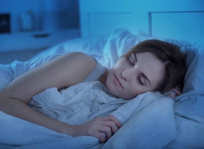 woman sleeping peacefully in bed at night after doing the drunken monkey exercise for better sleep