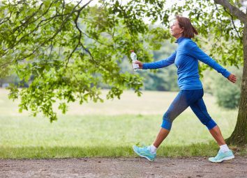 mature woman on brisk walk on trails, concept of low-impact exercises to melt belly fat