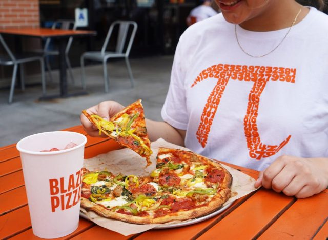 Blaze Pizza customer in a shirt with Pi symbol eating pizza