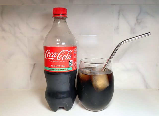 Coca-Cola bottle next to soda glass
