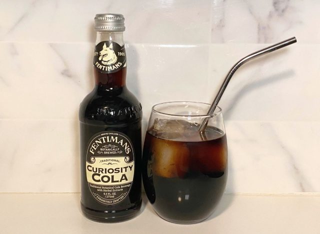 Bottle of Fentiman's Curiosity Cola next to a glass of soda