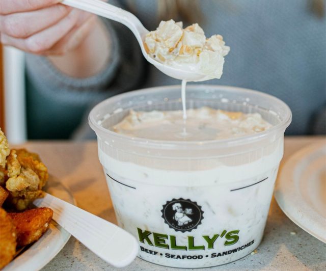 A diner is spooning up clam chowder from Kelly's Roast Beef