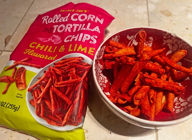 Trader Joe's chili lime rolled tortilla chips in a bowl beside the packaging