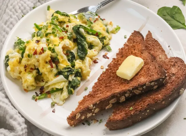 scrambled eggs and toast on a white plate