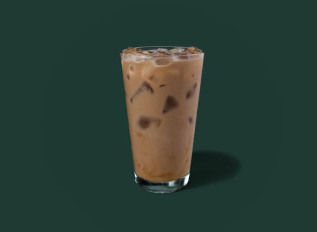 glass of Starbucks iced latte on a green background