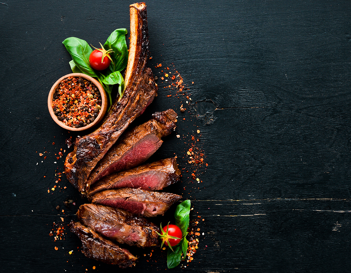 tomahawk steak On a black wooden background