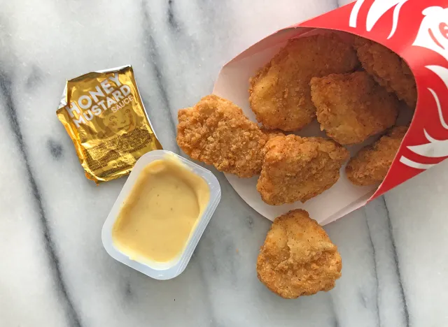 wendy's honey mustard dipping sauce with nuggets spilled out on a table.