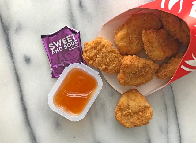 wendy's sweet and sour dipping sauce with nuggets spilled out on a table.