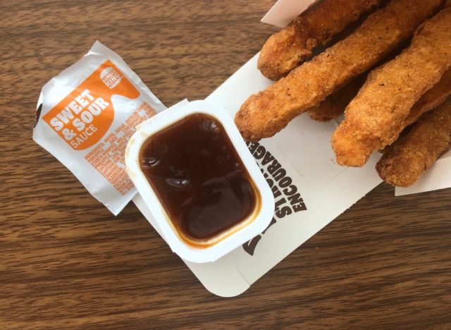 a packet of burger king sweet and sour with chicken fries on a table.