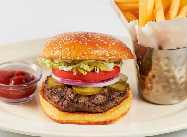 cheesecake factory burger, fries and ketchup on a plate.