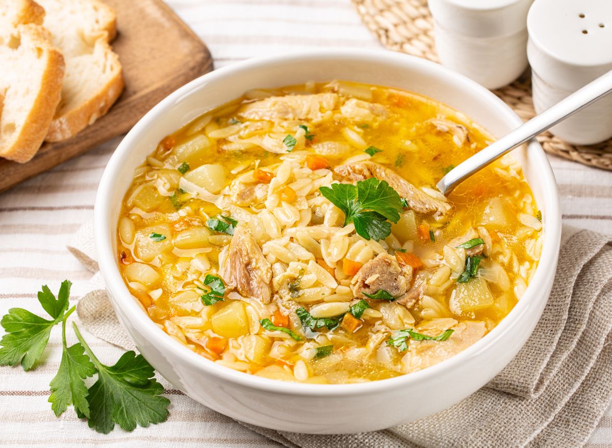 bowl of chicken and rice soup on a table with spoon