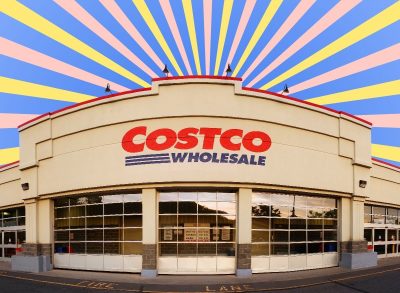 A Costco warehouse storefront against a colorful backdrop