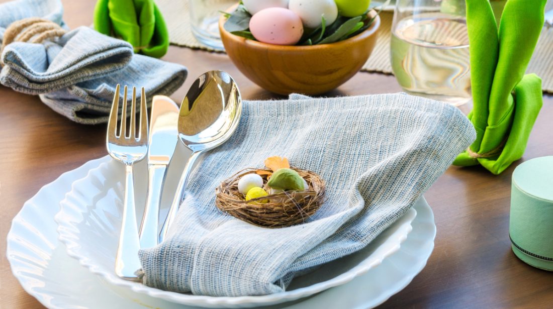 easter table setting with plates, silverware, napkins and easter egg decor