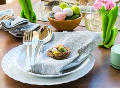 easter table setting with plates, silverware, napkins and easter egg decor
