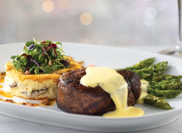 plate with eddie v's filet mignon, asparagus, and frittata topped with greens