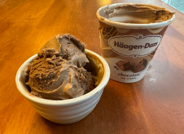 haagen-dazs ice cream container open on a table with a bowl of ice cream.