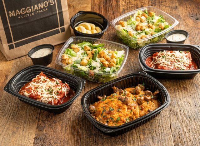 maggiano's takeout containers filled with salads and entrées next to a takeout bag