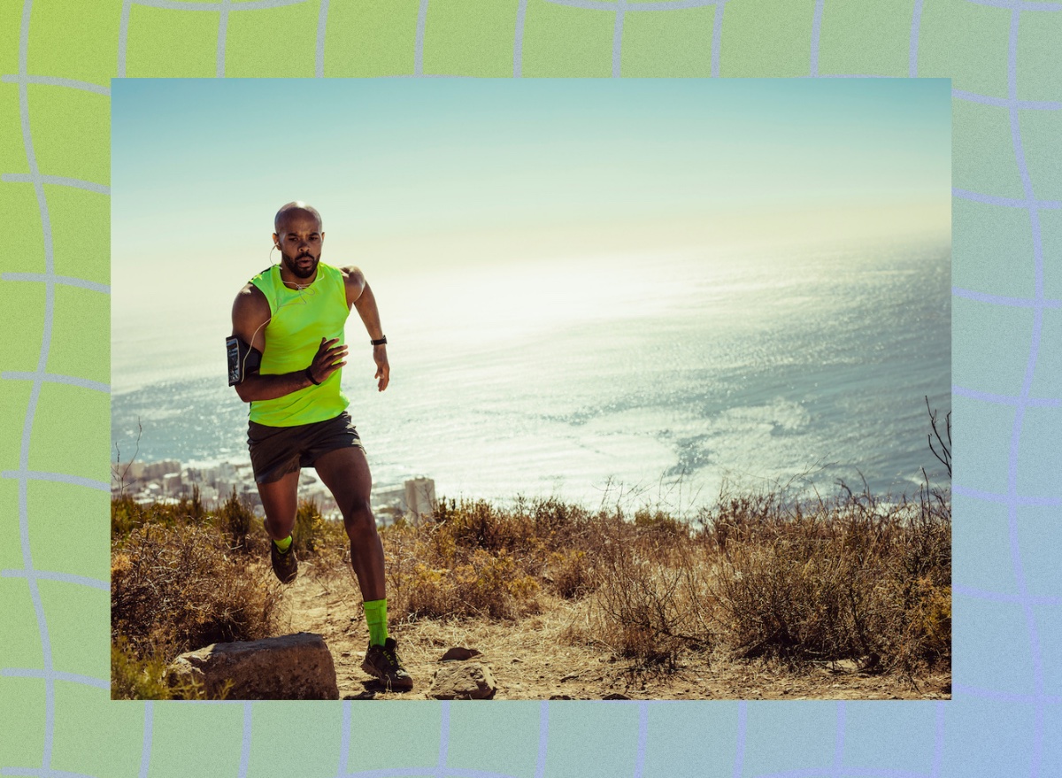 fit man in lime green tank top running outdoors on trail by the ocean on sunny day