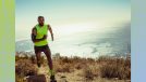 fit man in lime green tank top running outdoors on trail by the ocean on sunny day