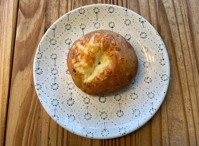 a panera asiago bagel on a printed plate.